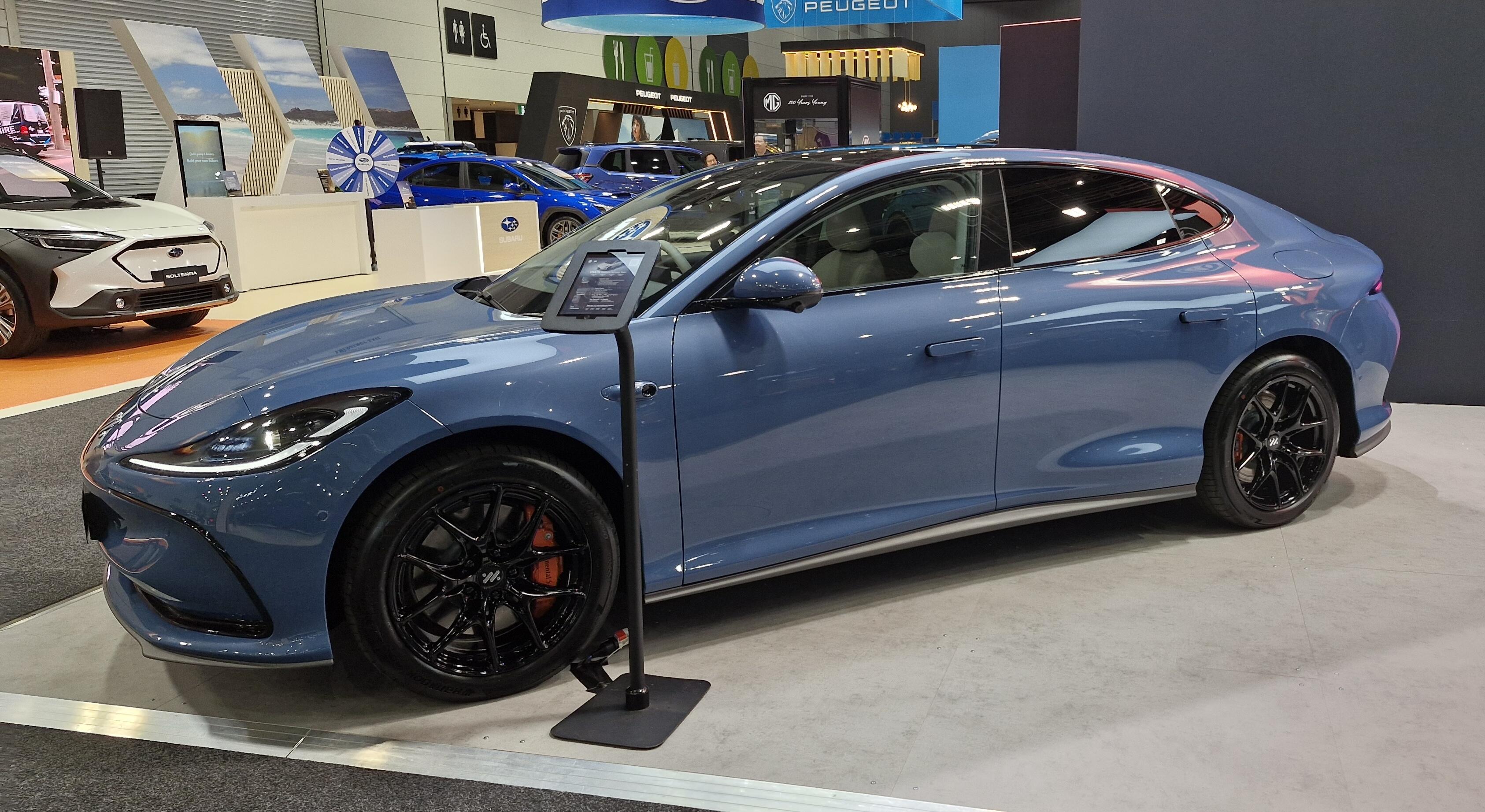 A blue sedan car with the IM logo on its tyres