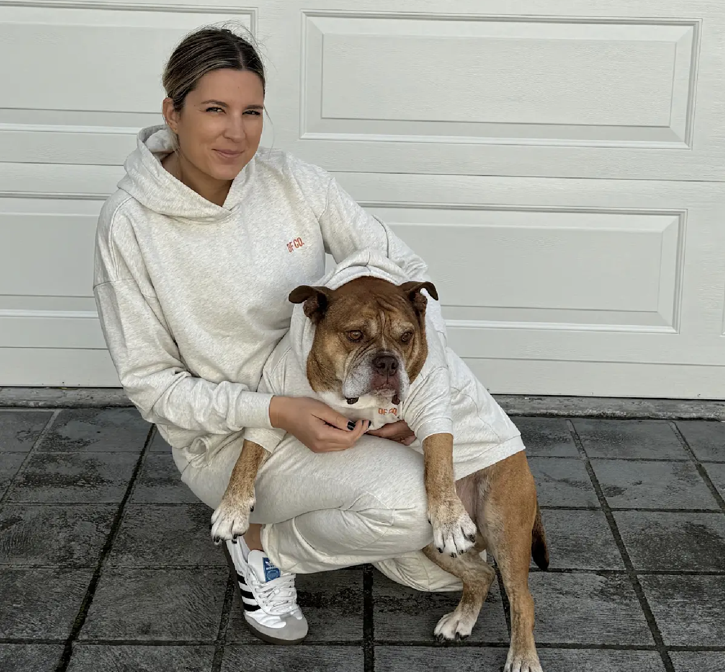 A woman and a bulldog in matching off-white DF CO. hoodies