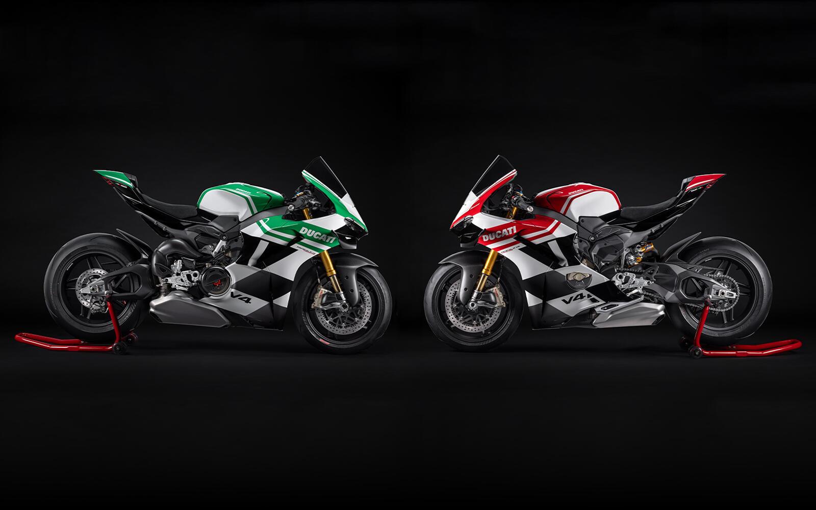 A green, white, and black-patterned Ducati motorcycle faces an identical red, white, and black-patterned motorcycle on a black background