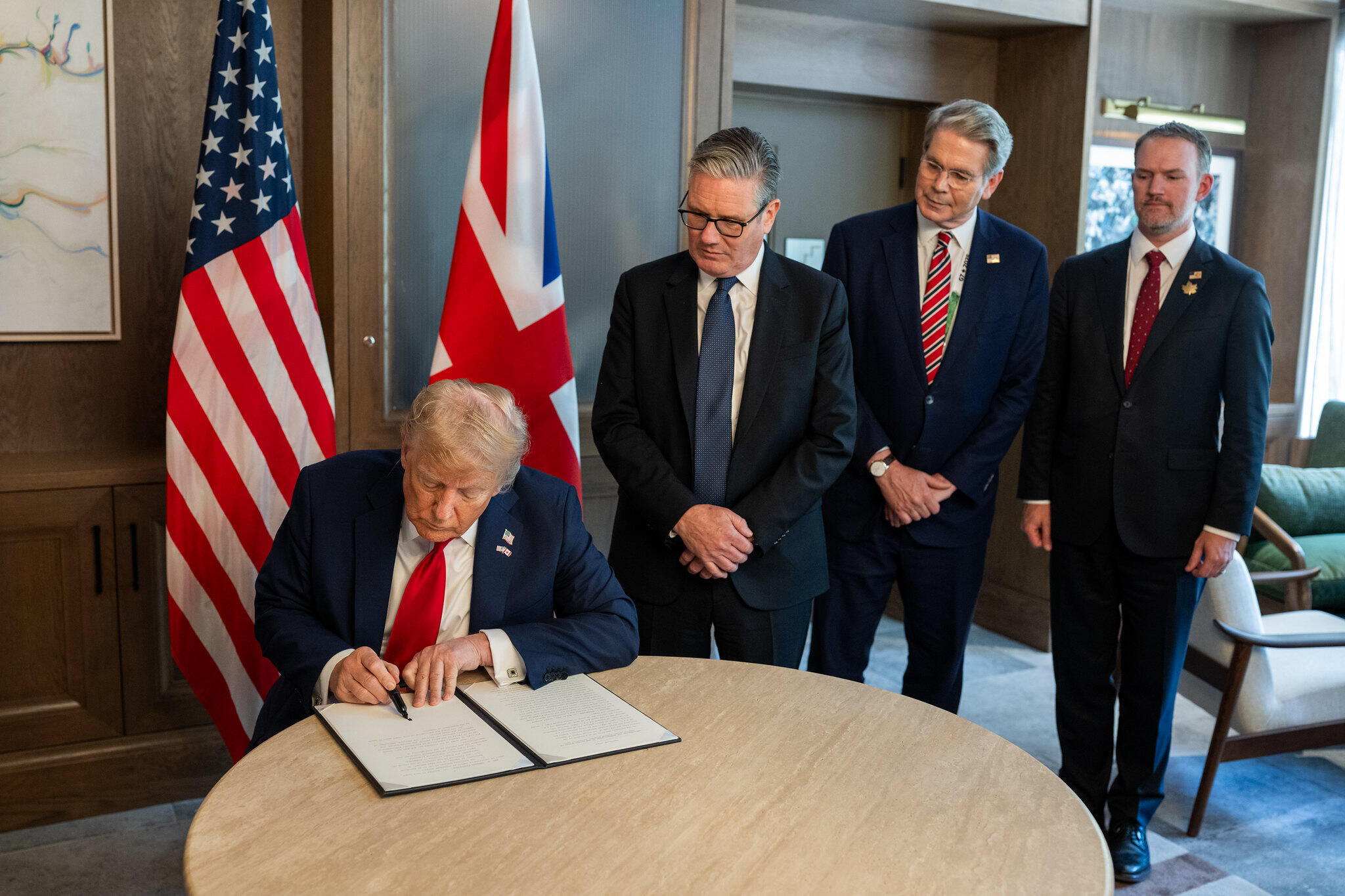 President Donald Trump signs a US-UK trade deal next to British Prime Minister Keir Starmer and Secretary of Treasury Scott Bessent at the G7 Summit, Monday, June 16, 2025