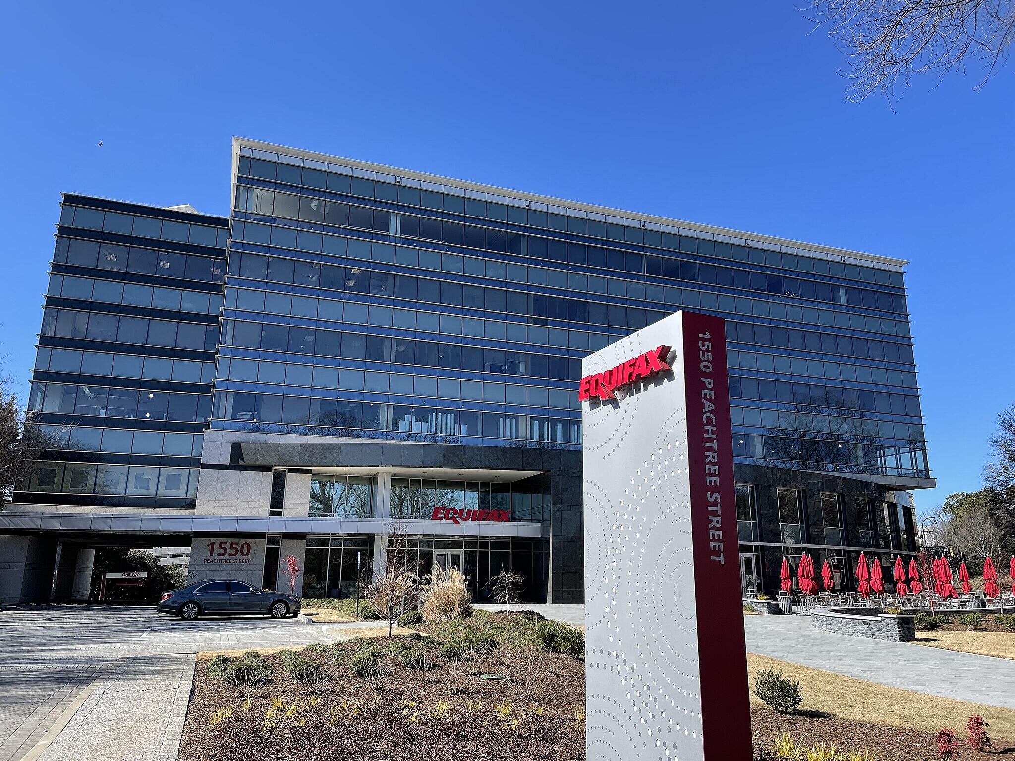 A silver sign reading "EQUIFAX" outside an office building