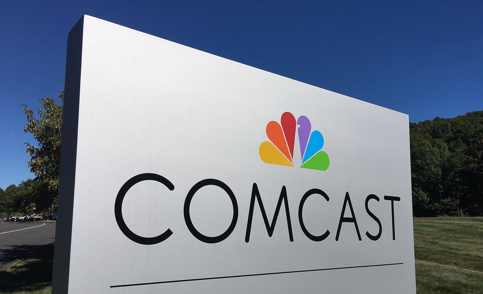 A silver sign outside saying "COMCAST" with its peacock logo