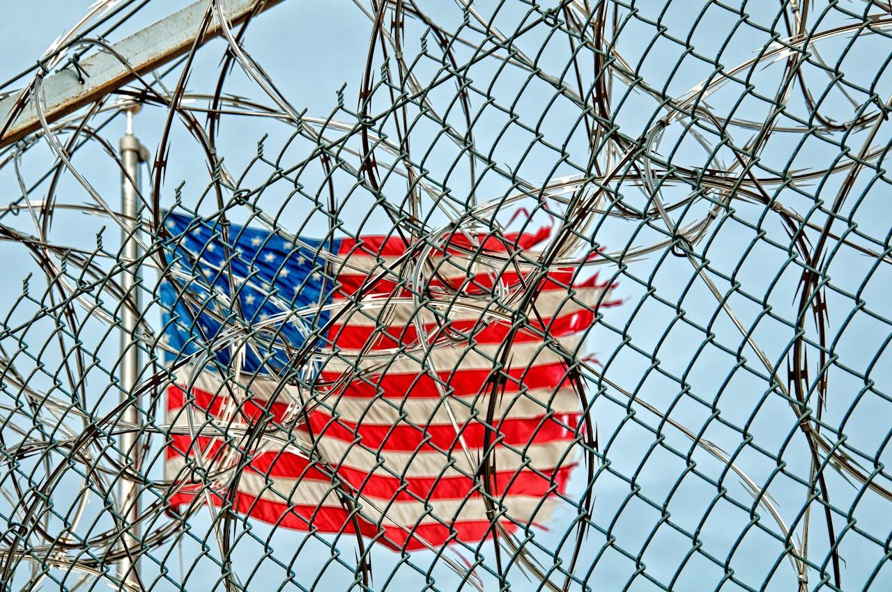 U.S. flag behind barbed wire.