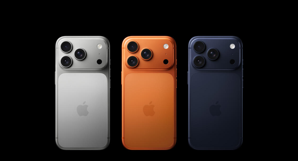 Silver, orange, and dark blue iPhones with three cameras each on a black background