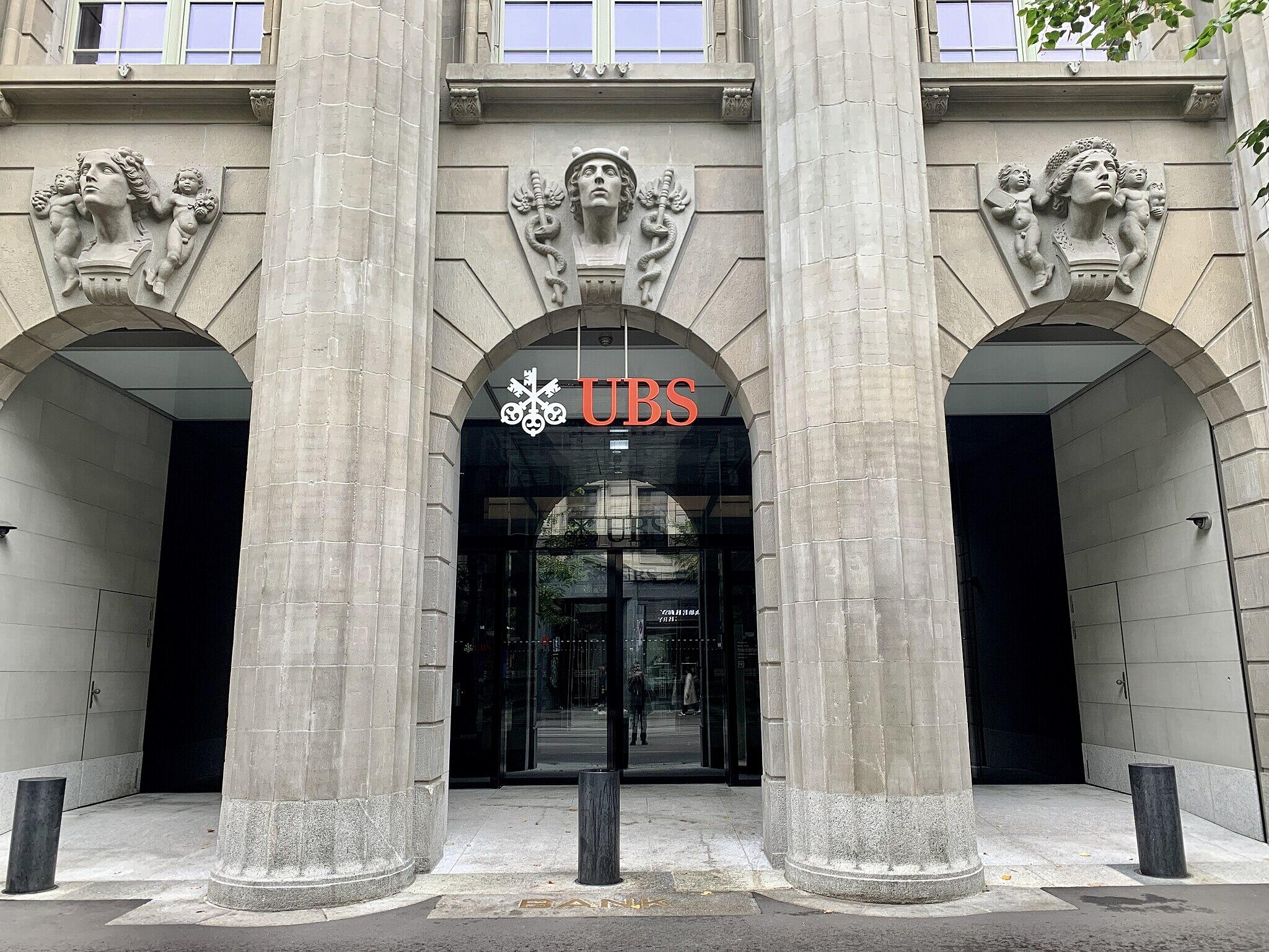 The UBS logo on a stone building with classical-style busts over arches