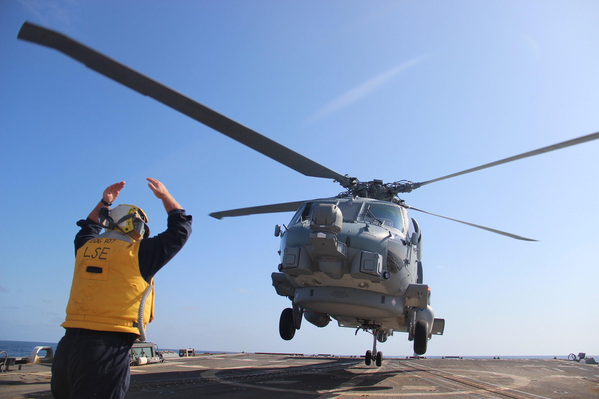An MH-60R helicopter attached to the Royal Danish navy Absalon-class command and support ship HMDS Absalon (L 16) lands on the flight deck of the U.S. Navy Arleigh Burke-class guided-missile destroyer USS Gravely (DDG 107) during a passing exercise (PASSEX) off the coast of Greenland, August 16, 2019.