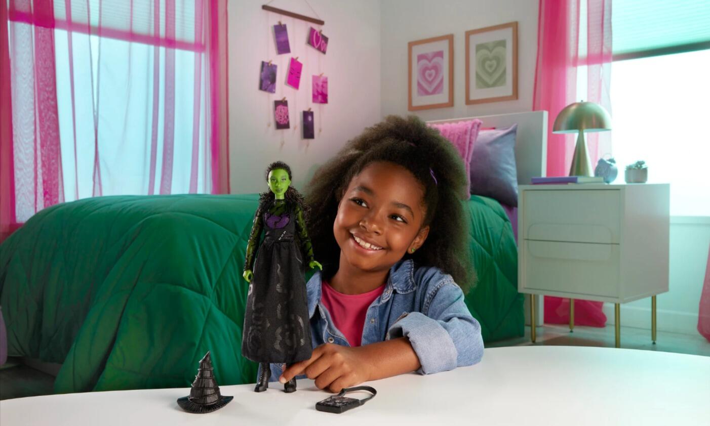 young girl plays with Elphaba barbie from wicked the film 